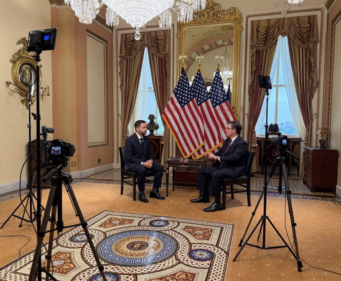 A two-camera mobile interview set up in a formal room with lights and tripods